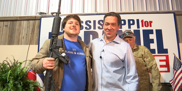 McDaniel poses with a supporter, who won the raffle for an AR-15 rifle ahead of Mississippi's special election.