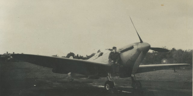 Photo of Flt. Lt. Alastair Gunn sat on a Spitfire.