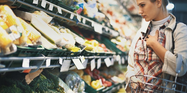 A woman buys groceries at the store. Health professionals and nutritionists should read food labels carefully. 