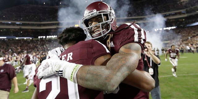 Texas A & M wide receiver, Kendrick Rogers, right, celebrates with Charles Oliver (21) after a college football match against the LSU on Saturday, Nov. 24, 2018, in College Station, Texas. Texas A & M won 74-72 in seven overtime. (Associated Press)