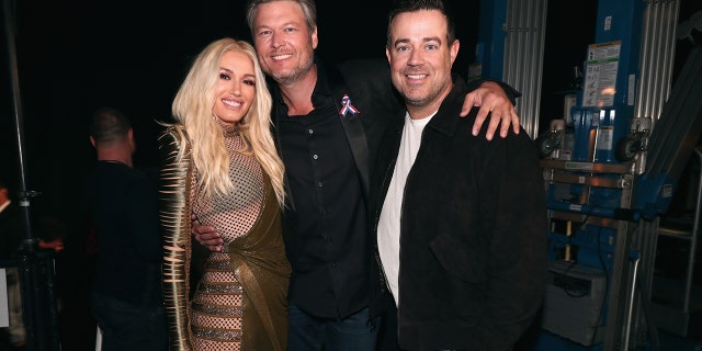 Pictured: (l-r) Recording artists-TV personalities Gwen Stefani and Blake Shelton and TV personality Carson Daly pose during the 2018 E! People's Choice Awards held at the Barker Hangar on November 11, 2018.