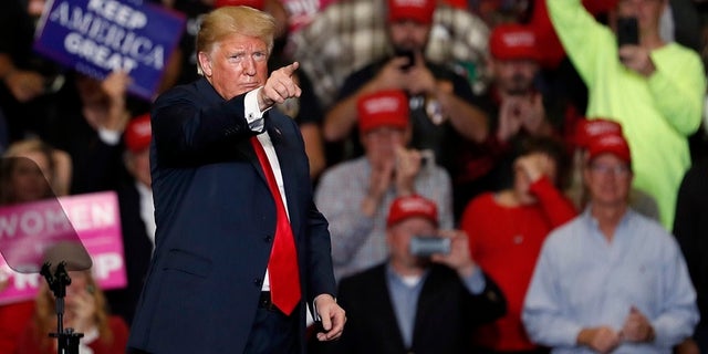 President Donald Trump points to the crowd as he leaves the stage at the end of a campaign rally Monday.