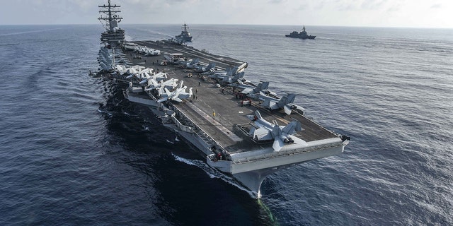 The aircraft carrier USS Ronald Reagan and the guided-missile destroyer USS Milius, center, conduct a photo exercise with Japan Maritime Self-Defense Force ships. (U.S. Navy)