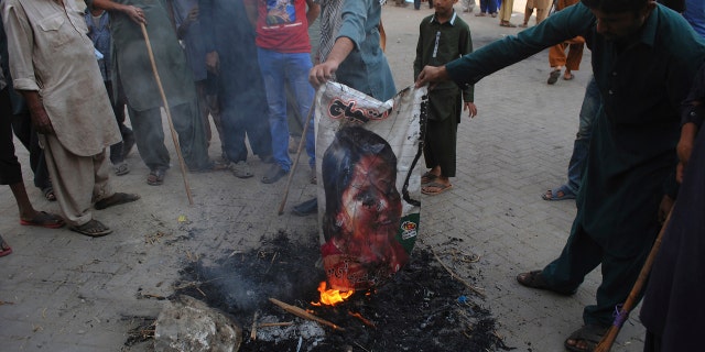 Pakistani protesters burn a poster image of Christian woman Asia Bibi in Hyderabad, Pakistan.