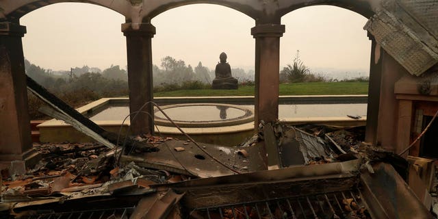 A Buddha statue is among the damage caused by a forest fire in a house in Malibu, California.