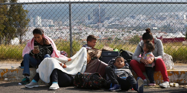 Central American migrants lie in front of a football stadium after arriving in Queretaro, Mexico, as they resume their journey north.