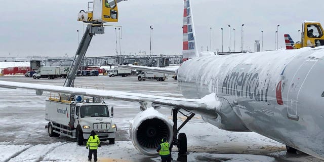 Crews de-ice an American Airlines plane at O'Hare International Airport on Monday, Nov. 26, 2018, in Chicago.