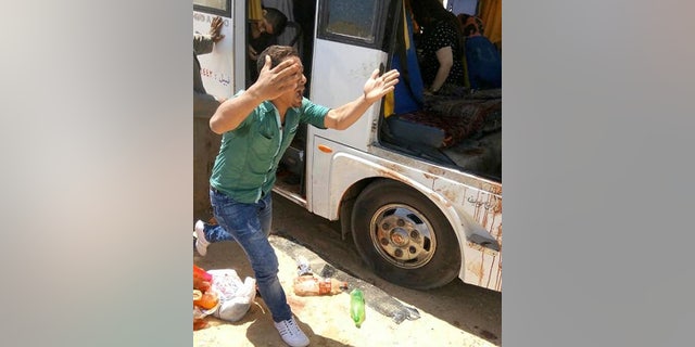 A man screams beside a bus carrying Coptic Christians which came under attack outside Cairo, Friday, Nov. 2, 2018.