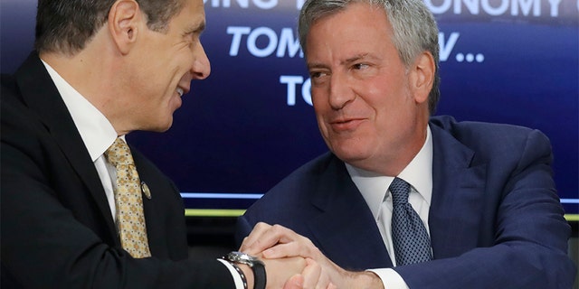 New York Gov. Andrew Cuomo, left, and New York City Mayor Bill de Blasio shake hands during a news conference Tuesday announcing the Amazon deal. Members of their own party are now criticizing the incentives package being offered to Amazon.