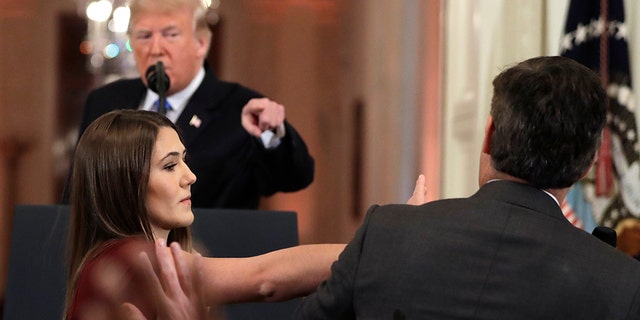 As President Donald Trump points to CNN's Jim Acosta, a White House aide takes the microphone from him during a news conference in the East Room of the White House, Wednesday, Nov. 7, 2018, in Washington. (AP Photo/Evan Vucci)