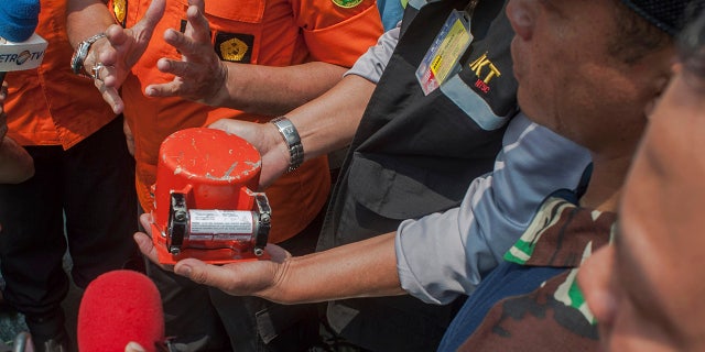 A member of National Transportation Safety Committee holds the flight data recorder from the crashed Lion Air jet on board of a research ship Baruna Jaya anchored in the waters of Tanjung Karawang, Indonesia on Thursday.