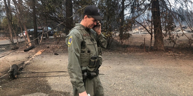 California Department of Fish and Wildlife warden Jake Olsen tells his wife her wedding ring was found in the ashes of their home they share with their four children in Paradise, Calif.