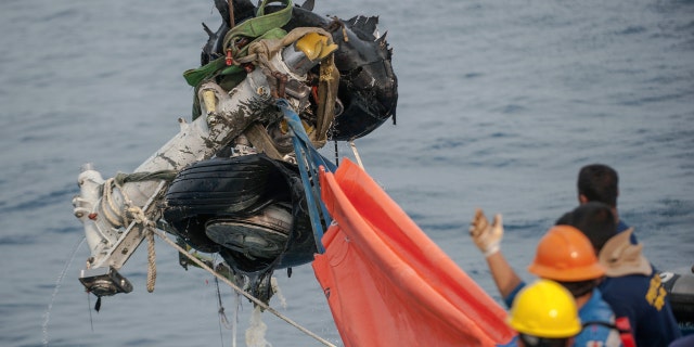 Rescuers use a crane to retrieve part of the landing gears of the crashed Lion Air jet from the sea floor in the waters of Tanjung Karawang, Indonesia, Sunday, Nov. 4, 2018.