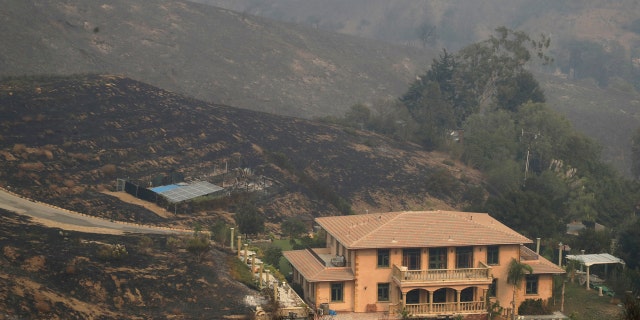 A home is spared after a wildfire swept through Saturday, Nov. 10, 2018, in Malibu, Calif.