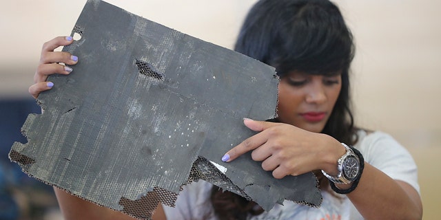 Grace Nathan, whose mother was on the ill-fated Malaysia Airlines Flight 370, shows a serial number on a piece of debris found in Madagascar that is "most likely" from MH370 at the Ministry of Transport in Putrajaya, Malaysia, Friday, Nov. 30, 2018.