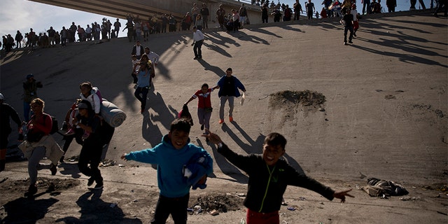 Migrants cross the river in Mexico-United States. Border after passing a line of Mexican police at Chaparral checkpoint in Tijuana, Mexico, on Sunday.