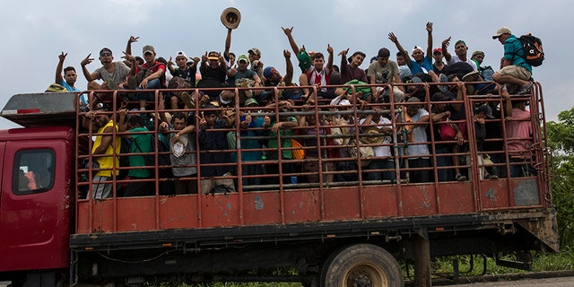 Members of one of the migrant caravans ride a truck in Donaji, Mexico.