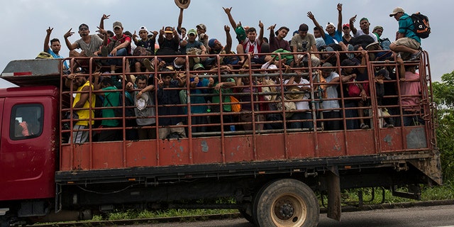 Members of a migrant caravan board a truck in Donaji, Mexico.