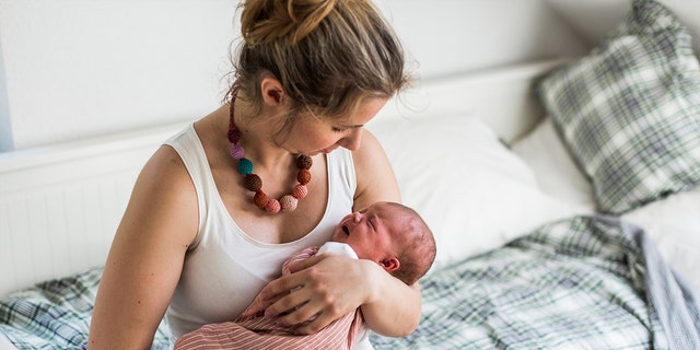 A new mom cuddles her newborn baby. PPD can be connected to the female body's major hormone shift, as well as a lack of sleep and a rise in worry.