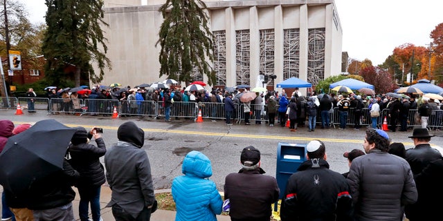 People line both sides of the street as they gather outside the Pittsburgh synagogue on Saturday.
