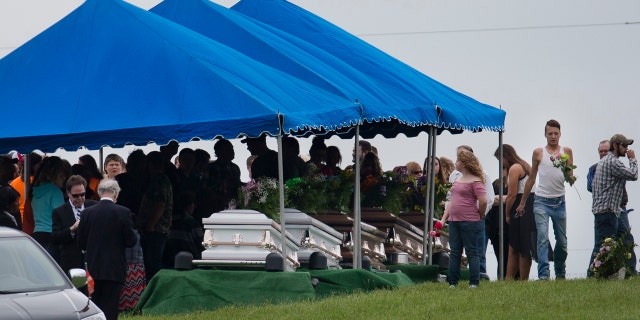 In this May 3, 2016, file photo, mourners gather around caskets for six of the eight members of the Rhoden family found shot April 22, 2016, at four properties near Piketon, Ohio.