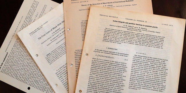 FILE - In this Friday, Oct. 19, 2018 file photo, documents and files by Stephen Hawking the personal and academic possessions of Stephen Hawking at the auction house Christies in London. A wheelchair used by Stephen Hawking has sold at auction for almost 300,000 pounds ($393,000), while a copy of the scientist's doctoral thesis fetched almost 585,000 pounds ($767,000). The motorized chair, used by the physicist after he was paralyzed with motor neuron disease, sold for 296,750 pounds in a Christie’s online auction on Thursday Nov. 8, 2018. (AP Photo/Frank Augstein, file)