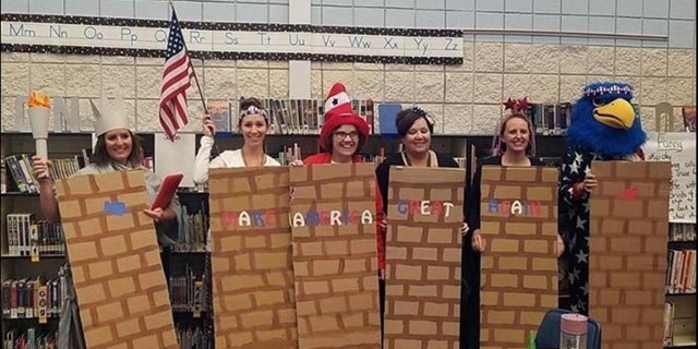 A school district is investigating after photos showed school employees dressed as a border wall.