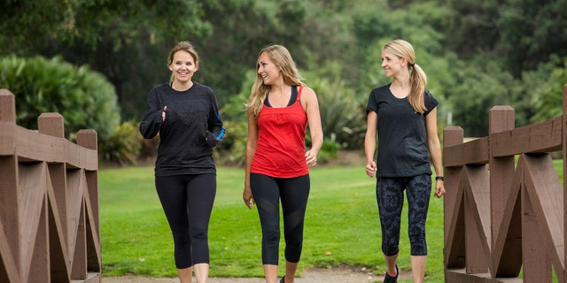 Group of women walk together in the outdoors. By using clothes that wick away sweat, exercise can be reasonably comfortable in the colder weather, said one exercise expert.
