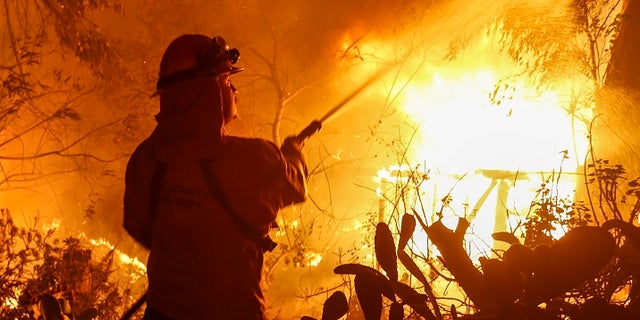 Firefighters battle the Woolsey Fire in Malibu, Calif.