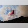 A plane drops fire retardant on a burning hillside in Malibu, California, November 11, 2018.