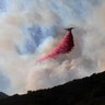 A plane drops fire retardant on a burning hillside in Malibu, California, November 11, 2018.