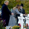 First lady Melania Trump, accompanied by President Trump and Rabbi Jeffrey Myers, puts down a white flower at a memorial for those killed at the Tree of Life Synagogue in Pittsburgh, Oct. 30, 2018. 