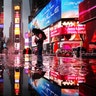 A man takes a picture during a rainstorm in Times Square in New York City, Nov. 26, 2018