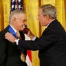 FILE - In this Nov. 17, 2008 photo, President George W. Bush presents the 2008 National Medals of Arts to comic book creator Stan Lee, in the East Room of the White House in Washington.