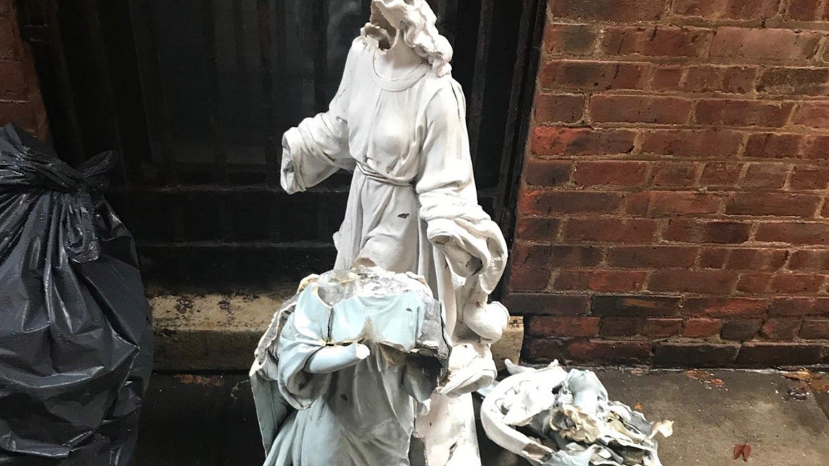 Police say video shows the man standing by the figures shortly before 4 a.m. Sunday in front of Our Lady of Consolation Roman Catholic Church on Metropolitan Avenue in Williamsburg.