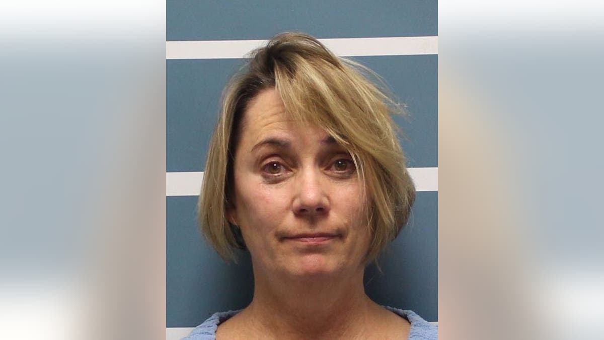 Margaret Gieszinger, 52, was arrested after she was seemingly caught in a video cutting a student's hair while incorrectly singing "The Star-Spangled Banner."