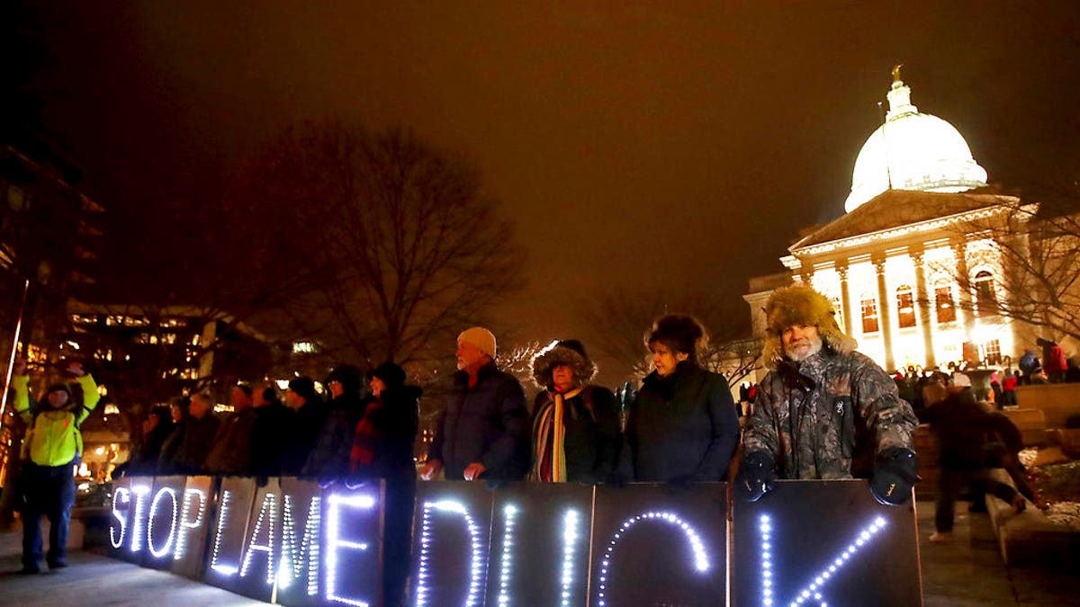 Opponents of an extraordinary session bill submitted by Wisconsin Republican legislators hold "Stop Lame Duck" signs at a rally outside the Wisconsin state Capitol in Madison, Wis., Monday, Dec. 3, 2018. (John Hart/Wisconsin State Journal via AP)