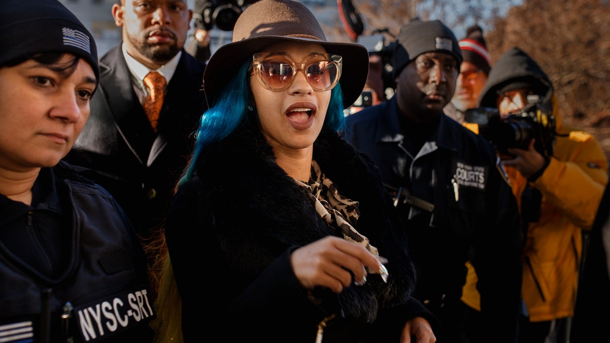 Rapper Cardi B, center, arrives at Queens County Criminal Court, Friday, Dec. 7, 2018, in New York. The platinum-selling hip hop star is scheduled to appear in court on charges related to a brawl at a New York strip club.
