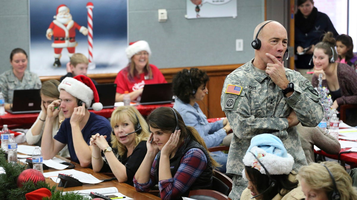 In this Dec. 24, 2014, file photo, NORAD Chief of Staff Maj. Gen. Charles D. Luckey takes a call while volunteering at the NORAD Tracks Santa center at Peterson Air Force Base in Colorado Springs, Colo. Hundreds of volunteers will help answer the phones from children around the world calling for Santa when the program resumes on Monday, Dec. 24, 2018, for the 63rd year. (AP Photo/Brennan Linsley, File)