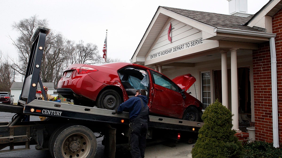 A car that crashed into the entrance of the Crossroads United Methodist Church is towed out of the doorway on Sunday, December 23, 2018 in Columbus, Ohio. A woman drove into the church during morning services, injuring several people. (Brooke LaValley/The Columbus Dispatch via AP)