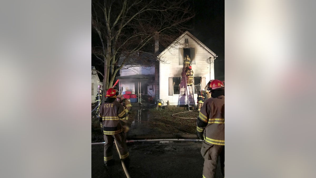 Firefighters work to extinguish a deadly fire on Friday in Tell City, Indiana.