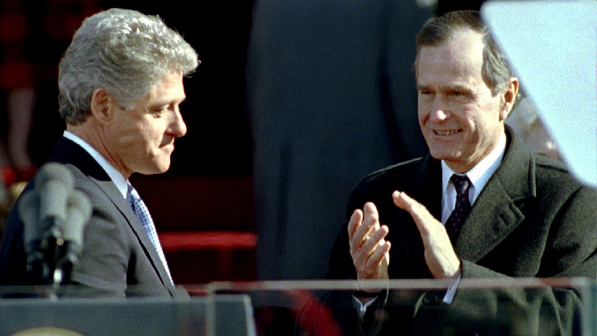 Outgoing President George Bush (R) applauds newly inaugurated President BIll Clinton (L) shortly after his swearing in, January 20