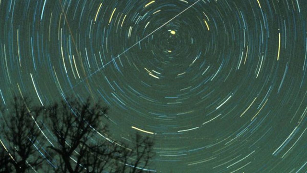 A Geminid meteor streaks across the sky.