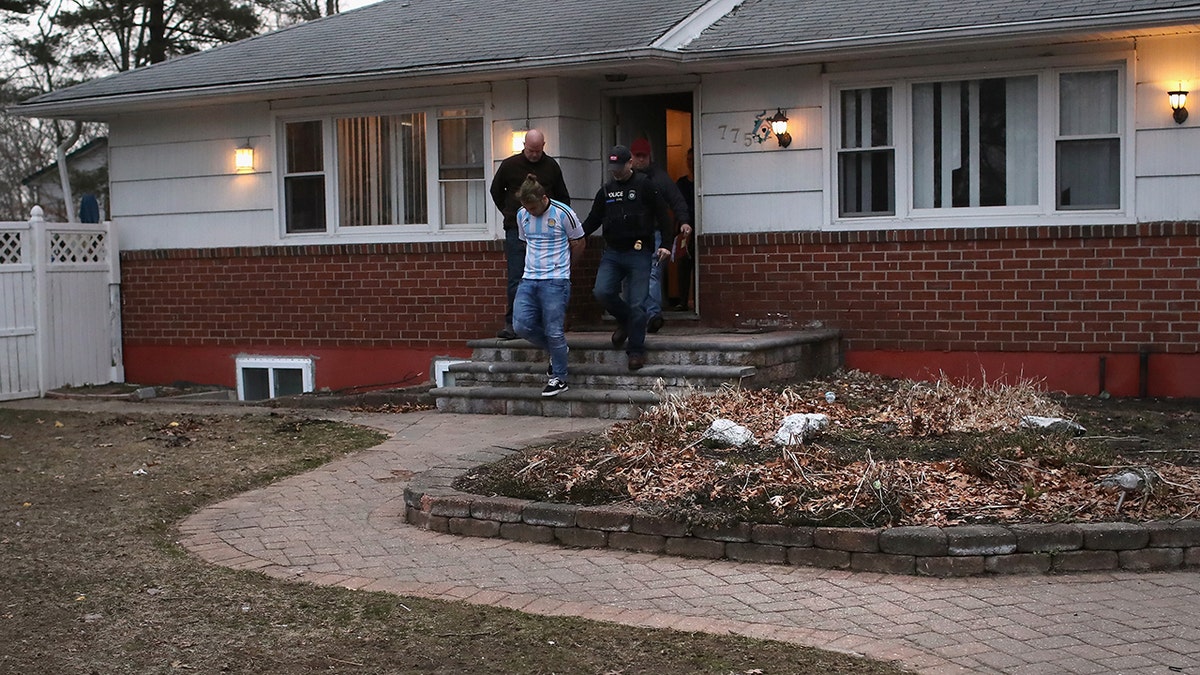 ICE agents detain a suspected MS-13 gang member and Honduran immigrant at his home in Brentwood, N.Y., in March.