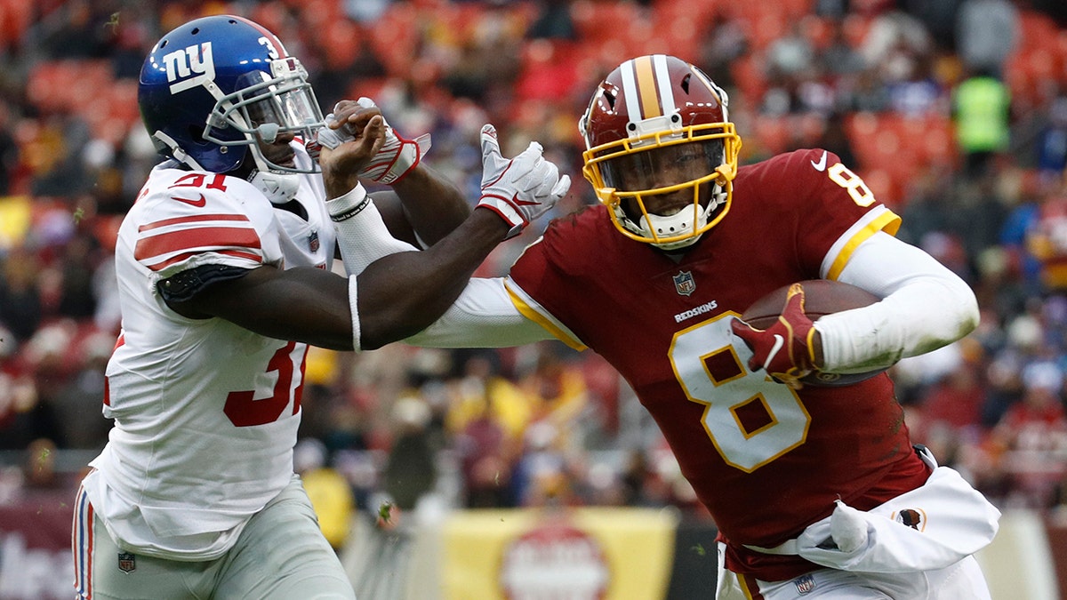 Washington Redskins quarterback Josh Johnson (8) tries to get away from New York Giants defensive back Michael Thomas (31) during the second half of an NFL football game Sunday, Dec. 9, 2018, in Landover, Md.