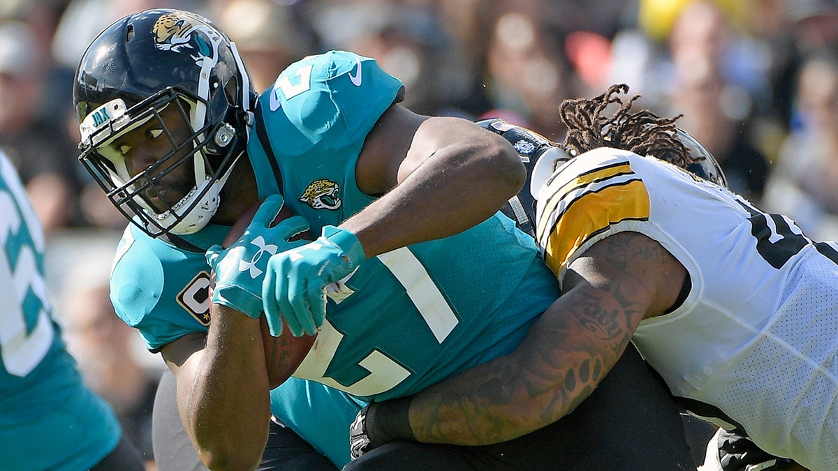 FILE - In this Nov. 18, 2018, file photo, Jacksonville Jaguars running back Leonard Fournette, left, runs for yardage as he is stopped by Pittsburgh Steelers outside linebacker Bud Dupree, right, during the first half of an NFL football game in Jacksonville, Fla.