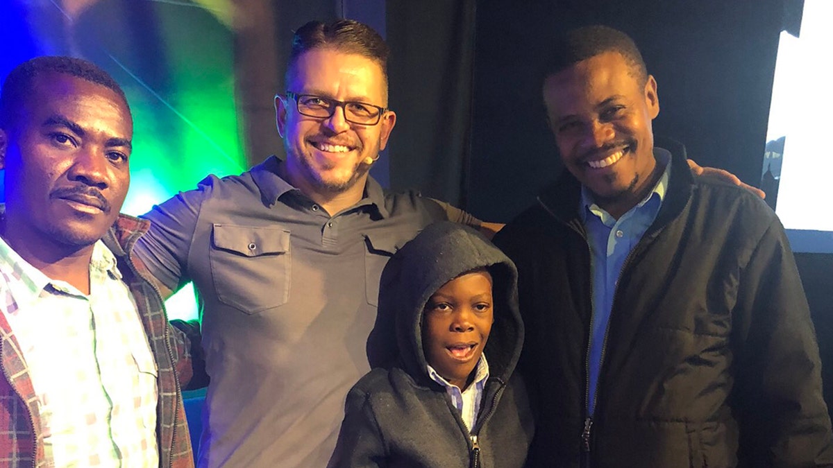 Pastor Paul Boutan of Calvary Chapel Brighton in Colorado poses with "Little John," his father, Jean Olivier, and their translator, Luccone Lucce Sunday following a successful surgery in Connecticut.