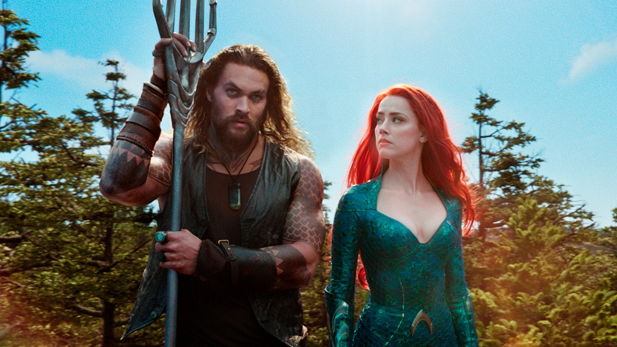 This image released by Warner Bros. Pictures shows Jason Momoa, left, and Amber Heard in a scene from "Aquaman."