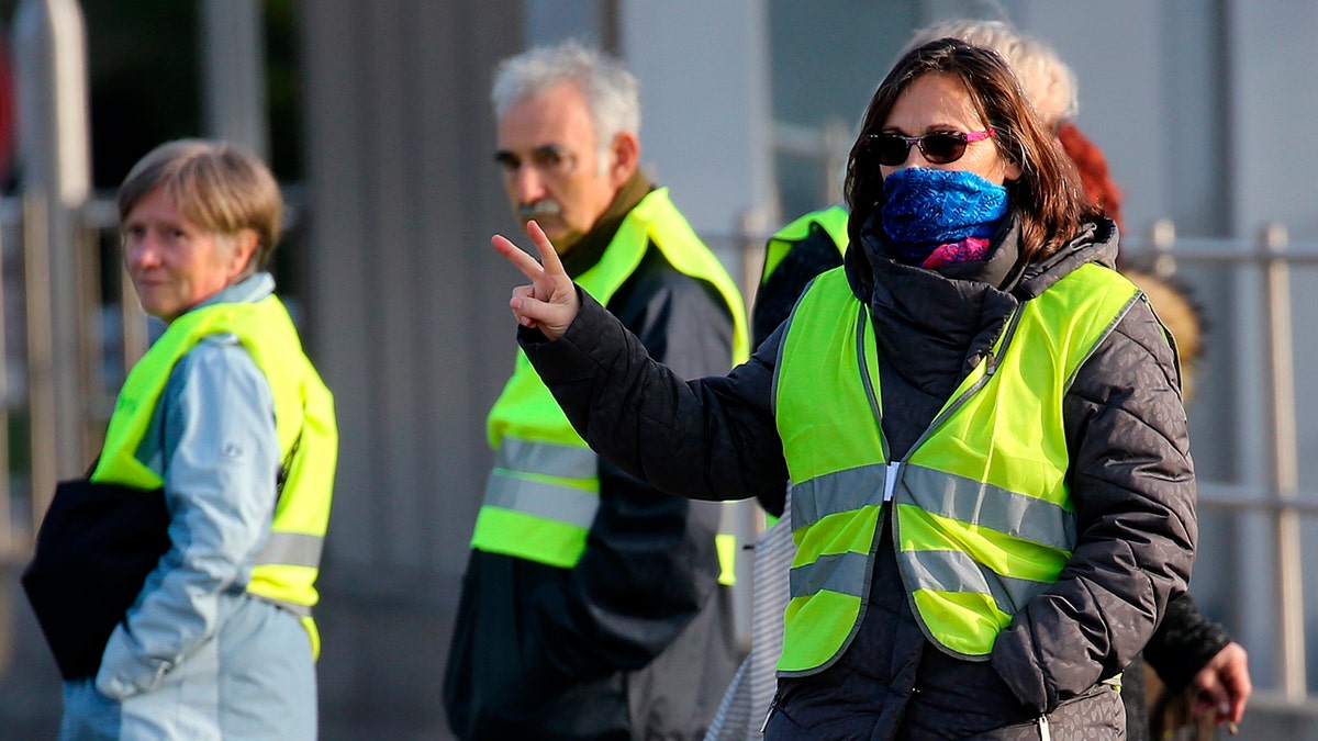 Demonstrators wearing yellow vests protest at the toll gates of a motorway, in Biarritz, southwestern France, Monday, Dec. 10, 2018.