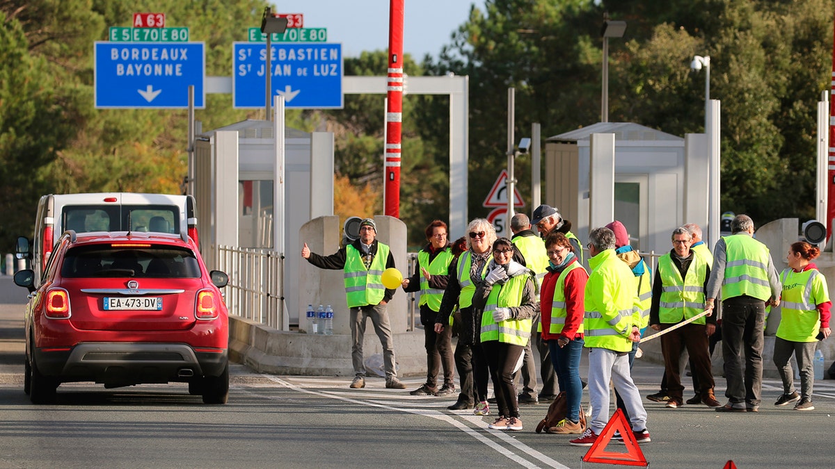 Demonstrators wearing yellow vests protest at the toll gates of a motorway, in Biarritz, southwestern France, Monday, Dec. 10, 2018.